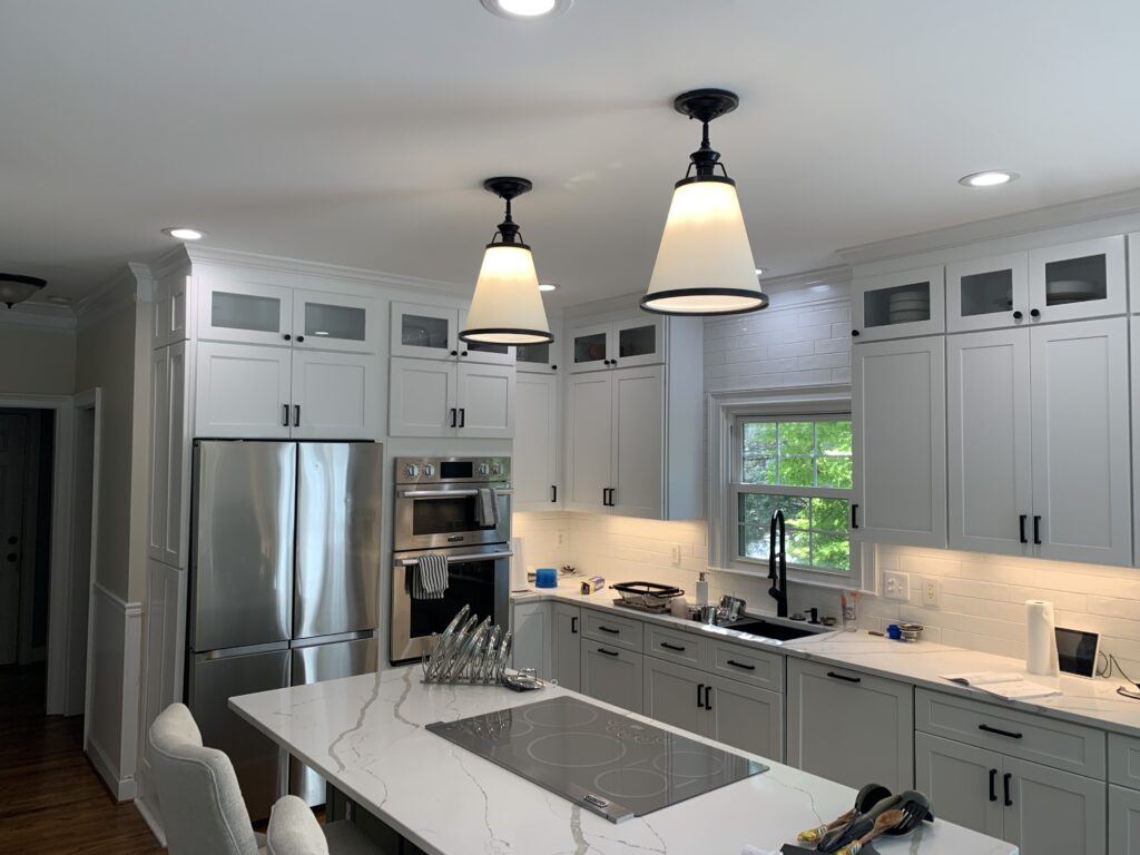 Person cleaning wood cabinets with a DIY vinegar and dish soap solution, using a soft cloth to wipe and polish the surface.