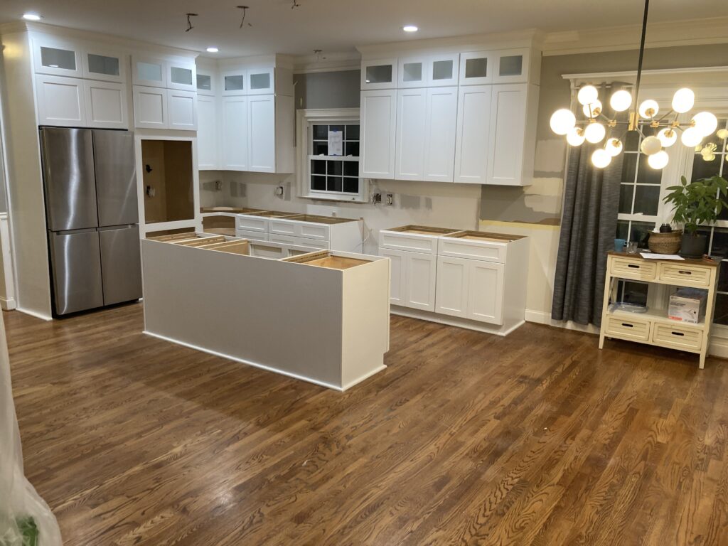 Display of various wood samples for kitchen cabinets, including oak, maple, hickory, cherry, and walnut, highlighting their colors and grain patterns
